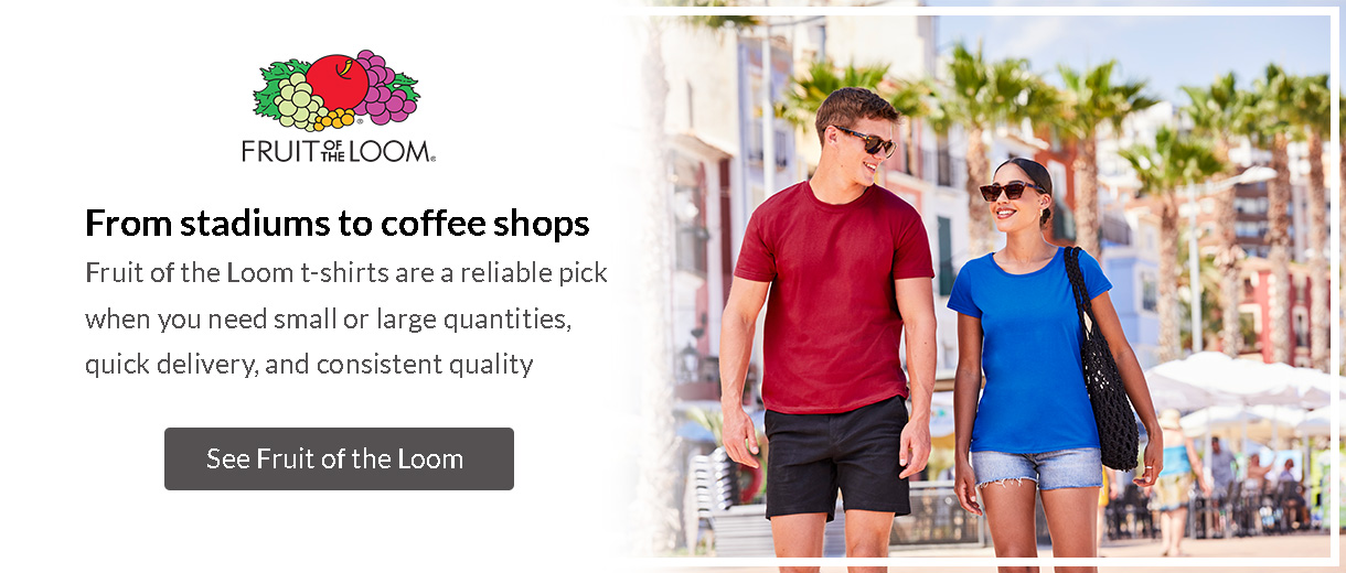 Man and woman wearing Fruit of the Loom t-shirts walking along a seaside promenade – perfect for branding.