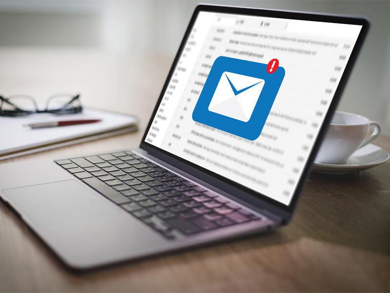 Laptop z wyświetloną ikoną powiadomienia o nowym emailu, symbolizujący zgłaszanie reklamacji przez internet