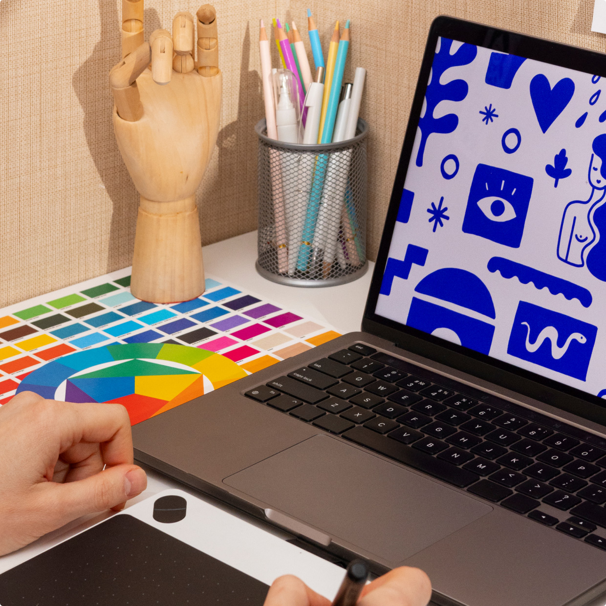 Stanowisko projektowe z laptopem i pr&oacute;bnikiem kolor&oacute;w do przygotowania grafiki do nadruku na odzieży